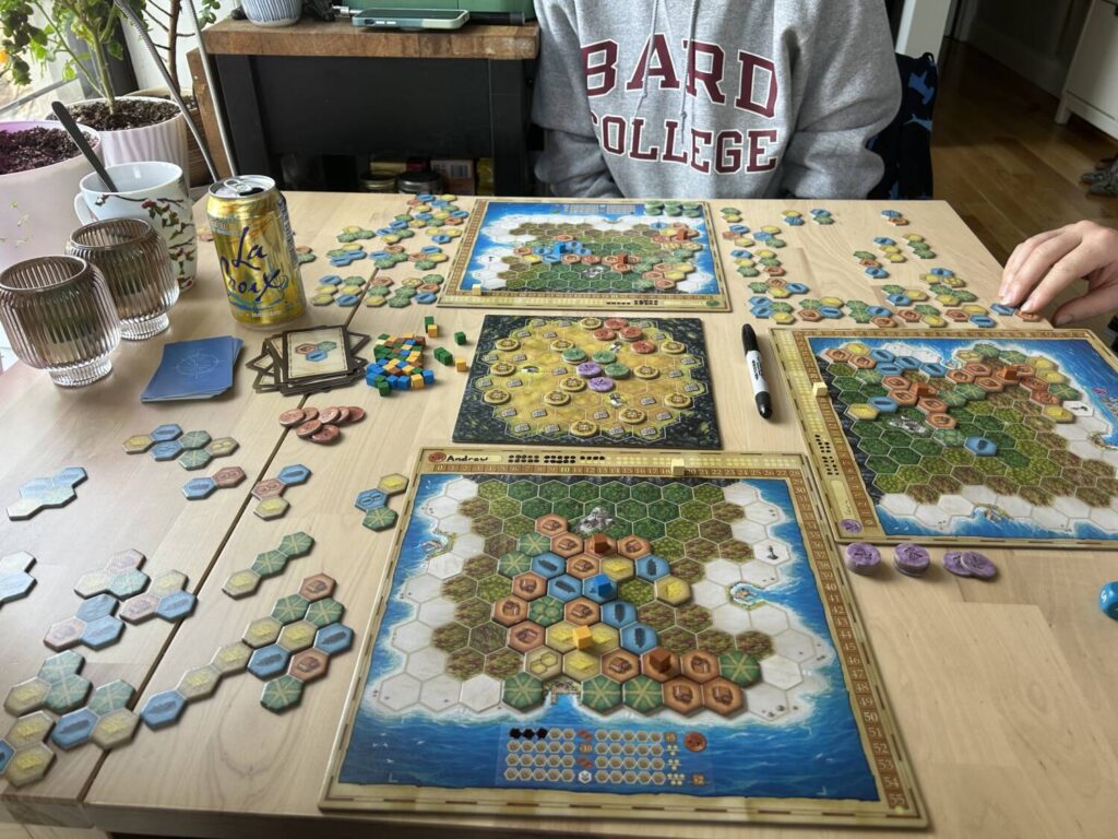 Mid-game, three players with islands spread across the table.