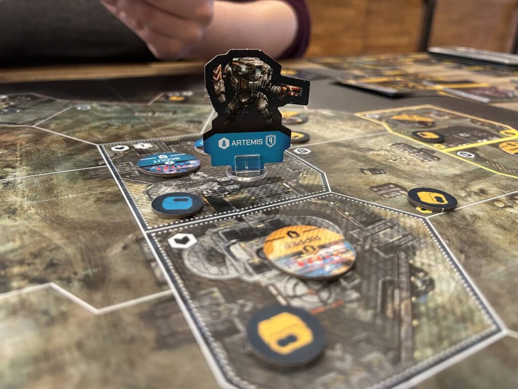 A mech standee lords over a section of the board, with enemy units in the adjacent sector.