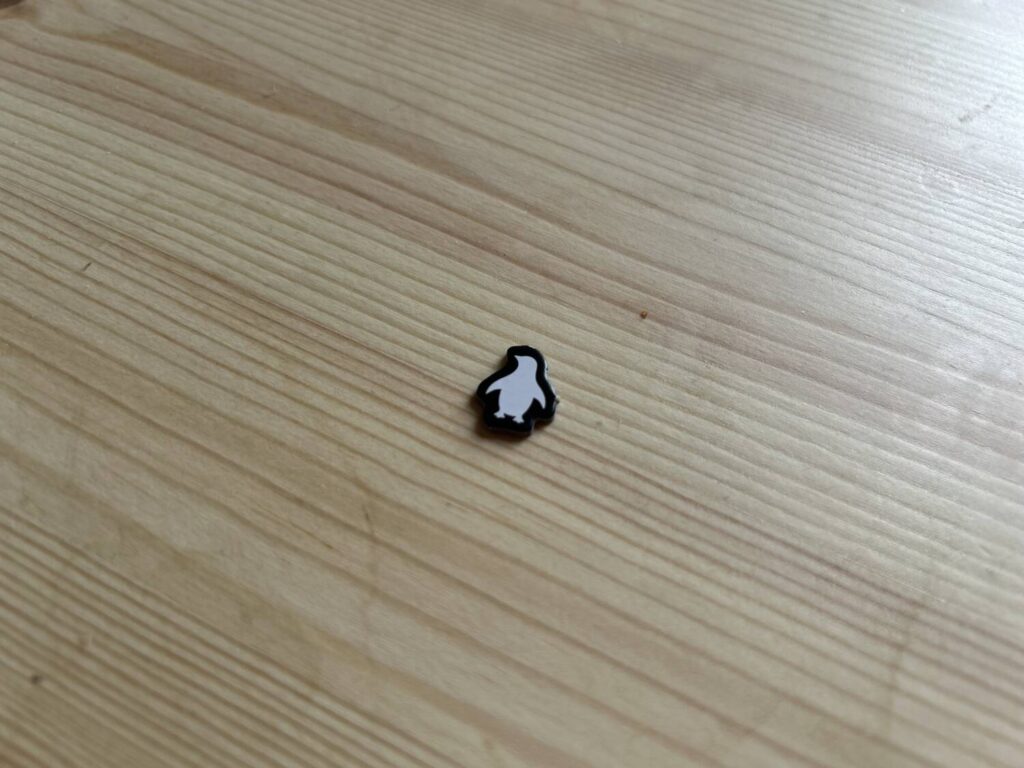 A solitary, small penguin-shaped cardboard token.