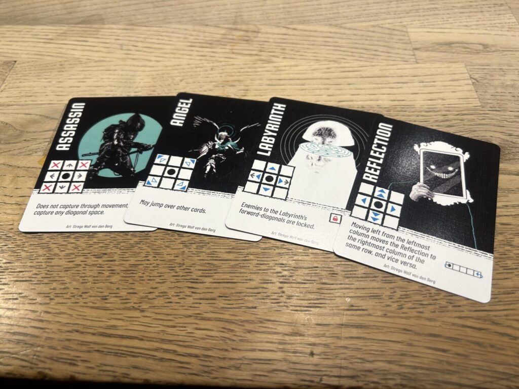 Four cards on a wooden table. Each card has a black background, with a white text box taking up the lower third of the card.