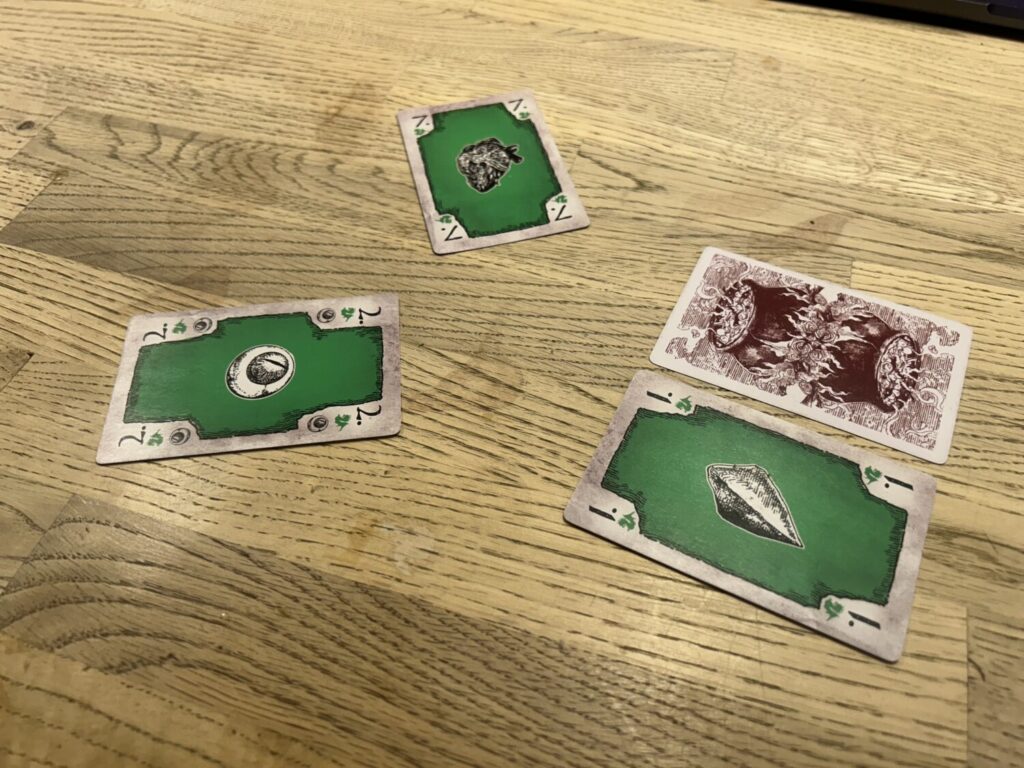 Four cards on a wooden table. Two of the cards are next to one another. One is face down. The other is faceup, and green. The two…</p>
<p>The post <a href=
